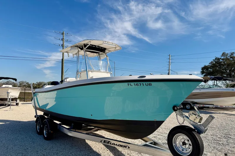 Slide: The Image of 2021 Cobia 237 Center Console boat on trailer under clear blue sky. - 4