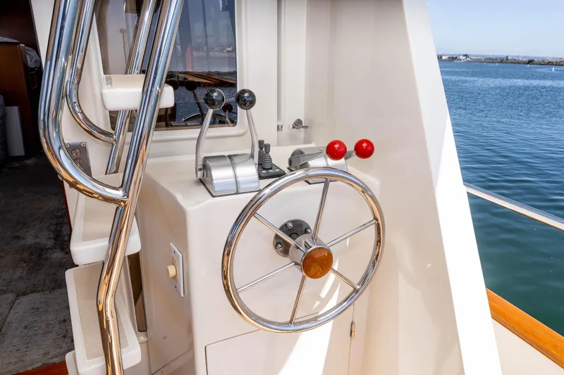Slide: The Image of Steering wheel and controls on a 2000 Offshore Yachts Flushdeck, overlooking the water. - 10