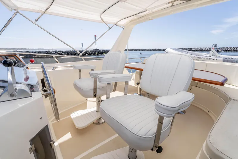 Slide: The Image of 2000 Offshore Yachts Flushdeck helm with white captain chairs and ocean view. - 23