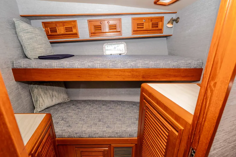 Slide: The Image of Cozy cabin interior of 2000 Offshore Yachts Flushdeck with wooden bunk beds and storage. - 35