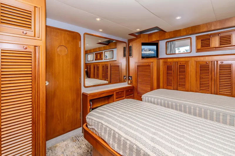 Slide: The Image of Luxurious 2000 Offshore Yachts Flushdeck cabin with twin beds and wooden cabinetry. - 37