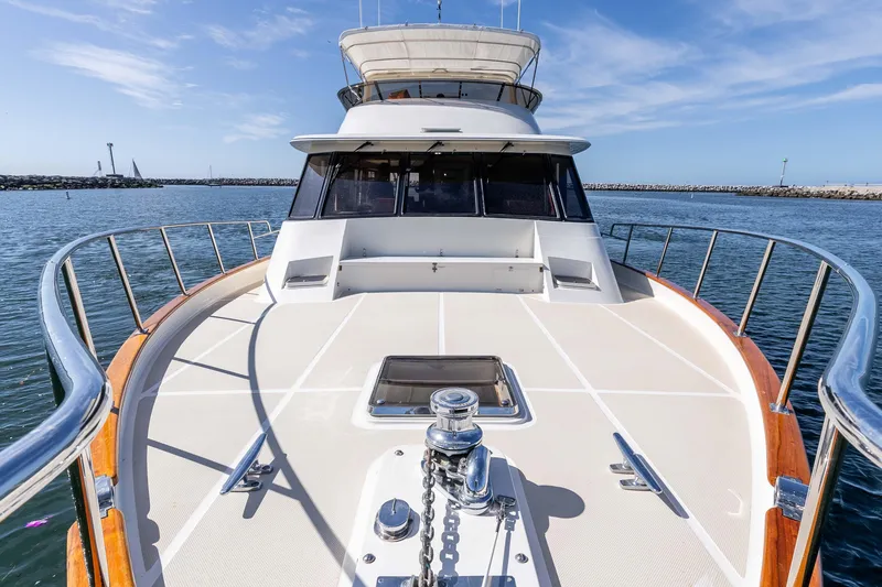 Slide: The Image of 2000 Offshore Yachts Flushdeck on calm water, showcasing spacious deck and sleek design. - 44