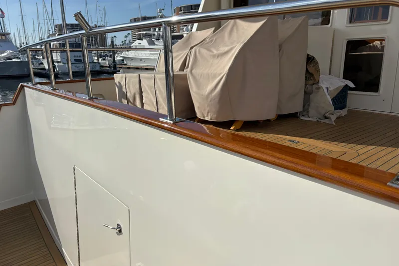 Slide: The Image of 2000 Offshore Yachts Flushdeck with covered deck furniture and polished railings in a marina setting. - 47