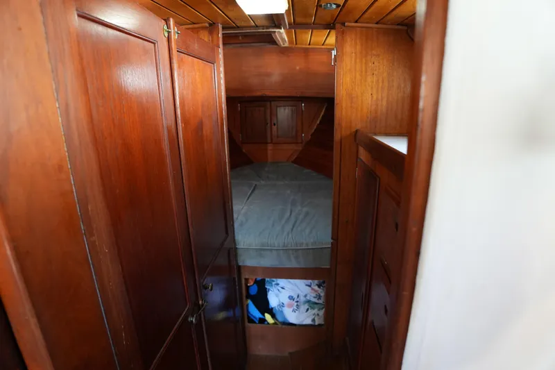 Slide: The Image of Interior of 1975 Westsail 32 sailboat with wooden cabinetry and cozy sleeping area. - 10