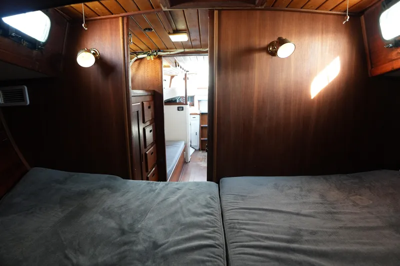 Slide: The Image of Cozy 1975 Westsail 32 yacht interior with wooden paneling and soft lighting. - 11