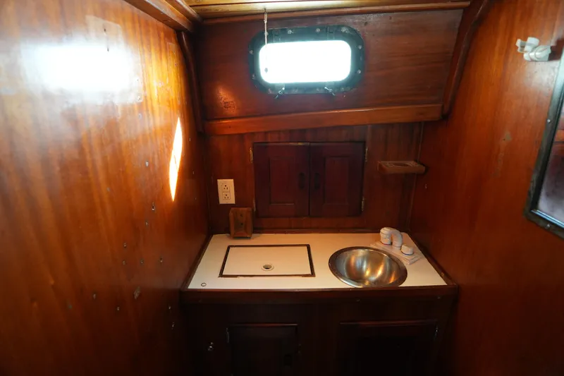 Slide: The Image of 1975 Westsail 32 boat interior with wooden cabinetry and stainless steel sink. - 14