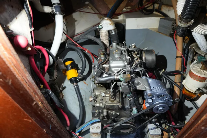 Slide: The Image of Engine compartment of a 1975 Westsail 32 sailboat, showing mechanical components and wiring. - 20
