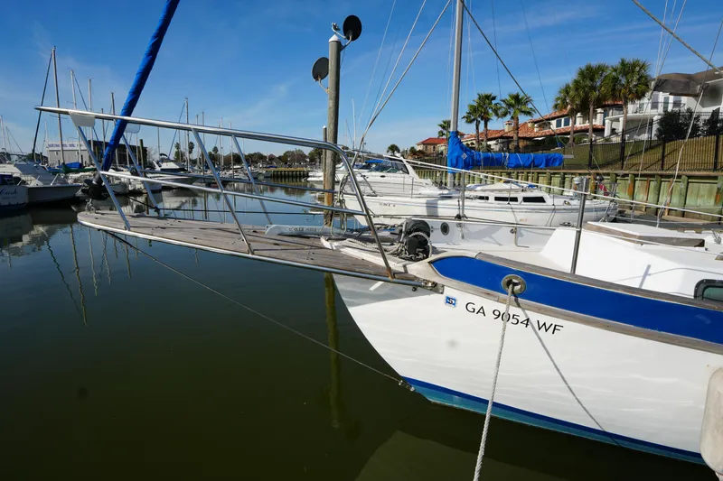 Slide: The Image of 1975 Westsail 32 sailboat docked in marina, featuring blue accents and calm water reflections. - 3