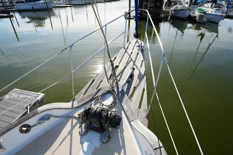 Slide: The Image of 1975 Westsail 32 sailboat bow at marina, calm water reflections. - 4