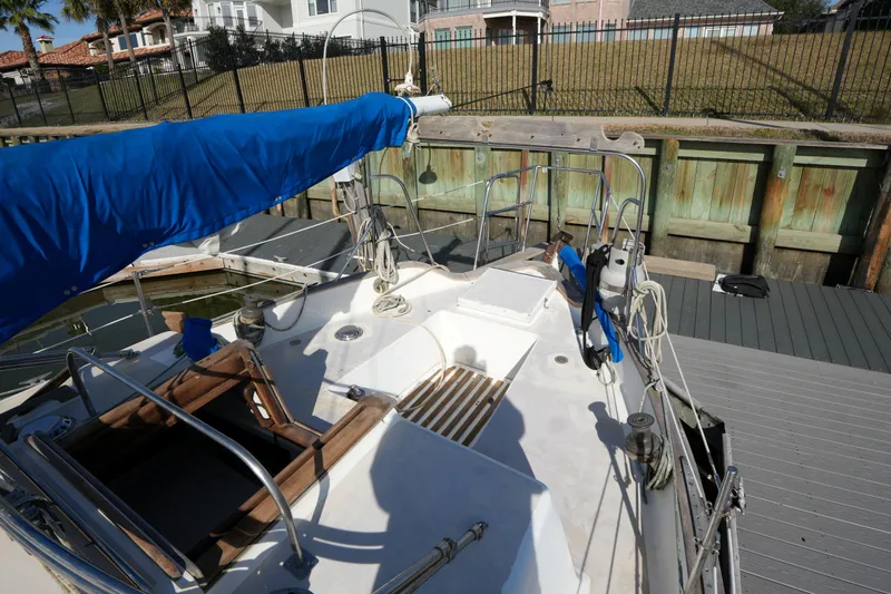 Slide: The Image of 1975 Westsail 32 sailboat docked, featuring blue sail cover and wooden deck details. - 6
