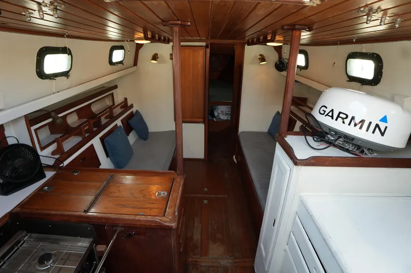 Slide: The Image of Interior of a 1975 Westsail 32 sailboat with wooden finishes and Garmin equipment. - 9