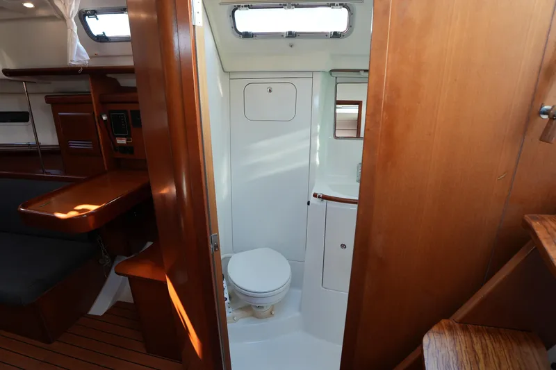 Slide: The Image of Interior of 2007 Beneteau 373 sailboat showing bathroom and wooden cabin features. - 22