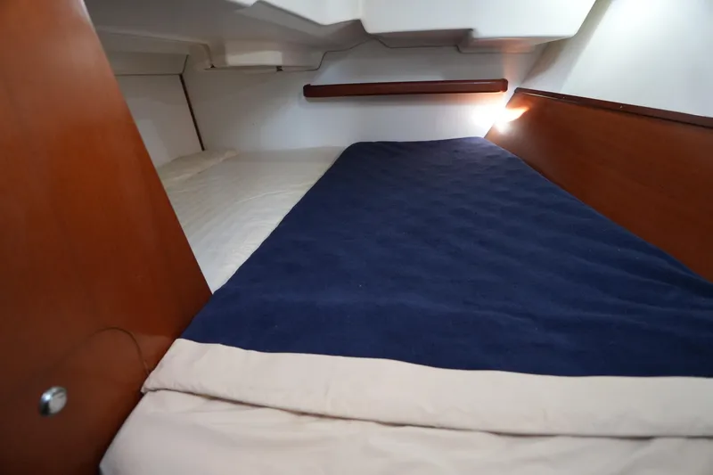 Slide: The Image of Cozy cabin interior of 2007 Beneteau 373 sailboat with blue bedding. - 25