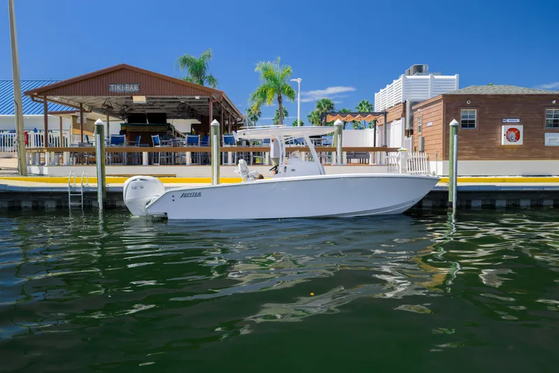 The Image of 2026 Jupiter 26 boat docked near a tiki bar under clear blue skies. - 2