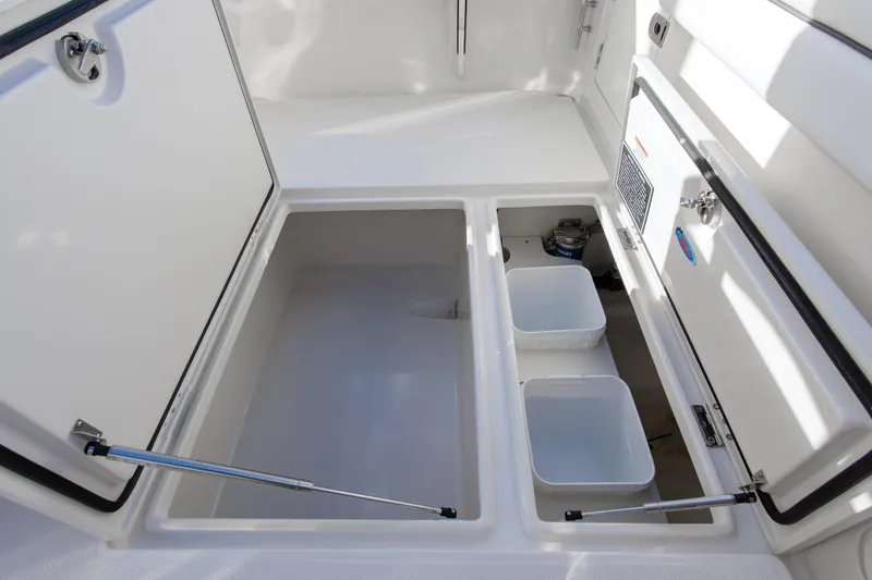 Slide: The Image of Open storage compartments on a 2026 Jupiter 26 boat, featuring organized bins and secure latches. - 16