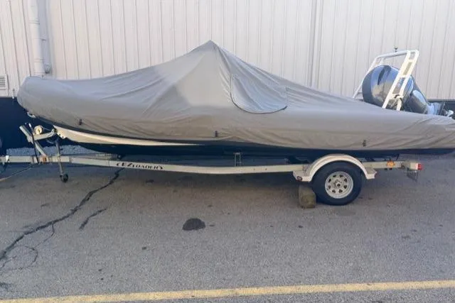Slide: The Image of 2019 Highfield 640 Deluxe boat covered on a trailer, parked outdoors. - 11