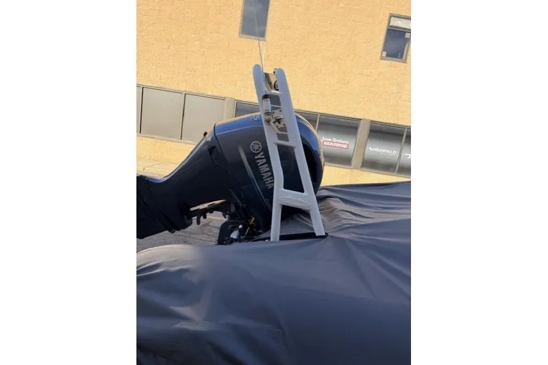 Slide: The Image of 2019 Highfield 640 Deluxe with Yamaha outboard motor, covered and parked outside a building. - 16