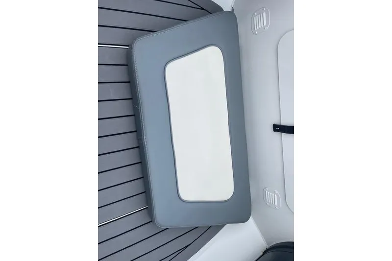 Slide: The Image of 2019 Highfield 640 Deluxe boat interior with gray and white cushioned seating. - 18