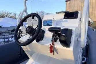 Slide: The Image of 2019 Highfield Patrol 660 boat console with steering wheel and controls. - 2