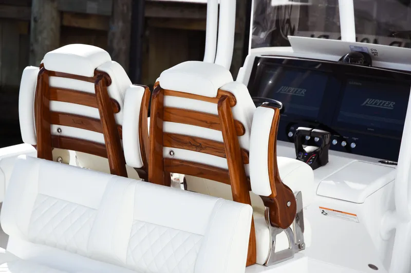 Slide: The Image of Luxury seating and dashboard of 2026 Jupiter 30 boat with wooden accents and modern controls. - 16
