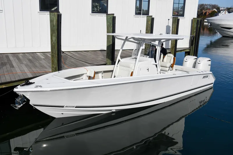 Slide: The Image of 2026 Jupiter 30 boat docked, featuring sleek design and twin engines. - 2