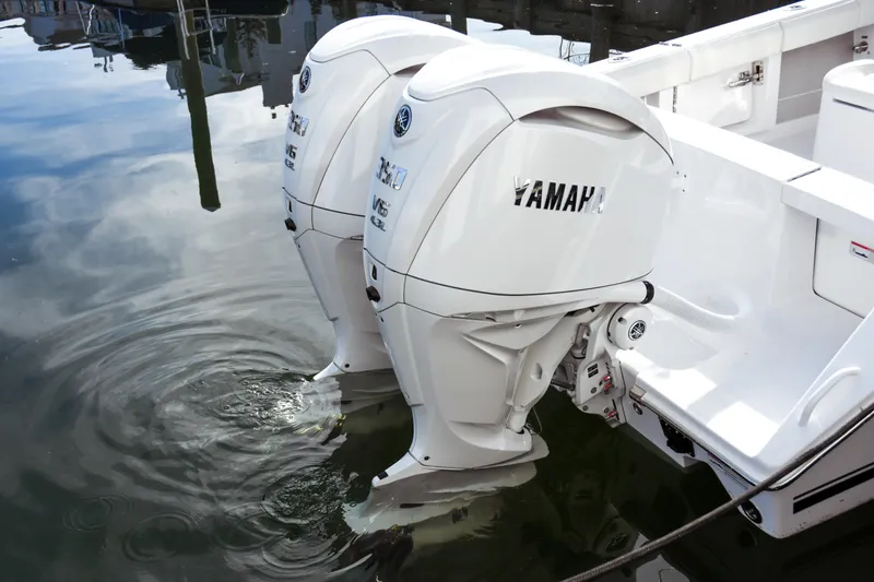 Slide: The Image of Twin Yamaha outboard motors on a 2026 Jupiter 30 boat, reflecting in calm water. - 21
