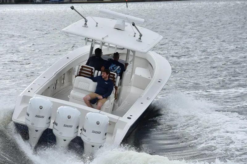 Slide: The Image of Manufacturer Provided Image: 2026 Jupiter 34 boat cruising on water with triple outboard engines. - 2