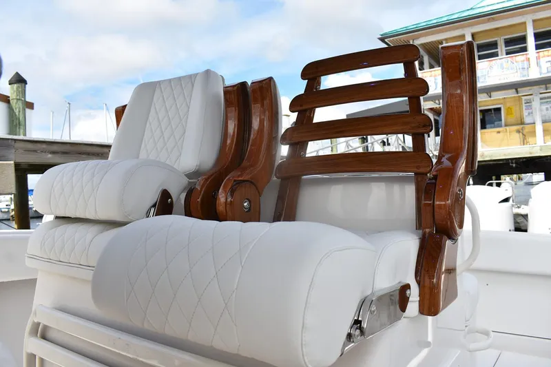 Slide: The Image of Manufacturer Provided Image: Luxurious seating on a 2026 Jupiter 34 boat, featuring white cushions and wooden accents. - 8