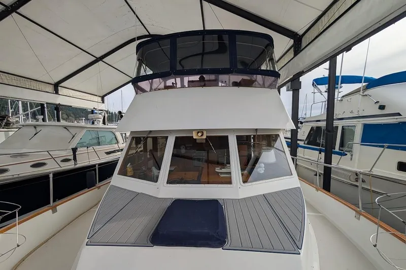 Slide: The Image of 1987 DeFever Trawler yacht docked under a covered marina. - 2