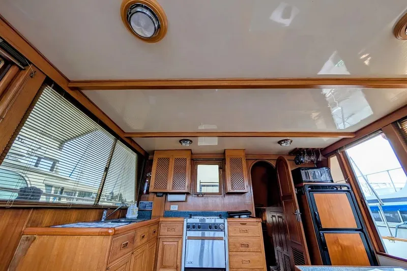 Slide: The Image of 1987 DeFever Trawler interior kitchen with wooden cabinetry and modern appliances. - 22