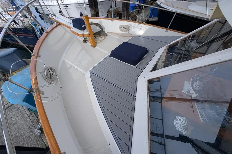 Slide: The Image of 1987 DeFever Trawler boat deck with wooden railings and seating area. - 3