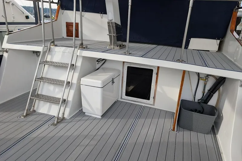 Slide: The Image of 1987 DeFever Trawler deck with ladder, storage box, and marine equipment. - 30