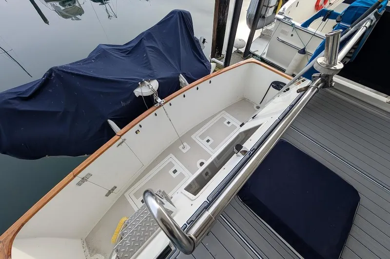 Slide: The Image of 1987 DeFever Trawler deck with covered equipment and stainless steel railings. - 37