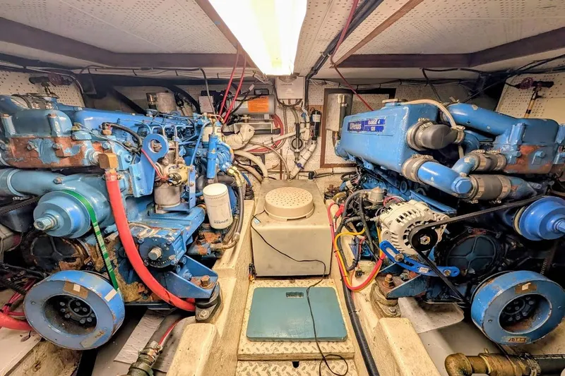 Slide: The Image of Engine room of a 1987 DeFever Trawler with dual blue marine engines. - 40