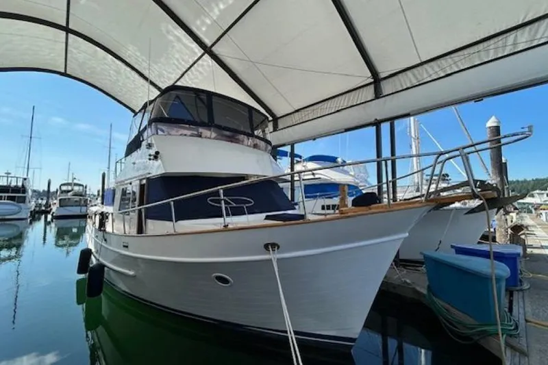 Slide: The Image of 1987 DeFever Trawler docked under a canopy in a marina. - 1