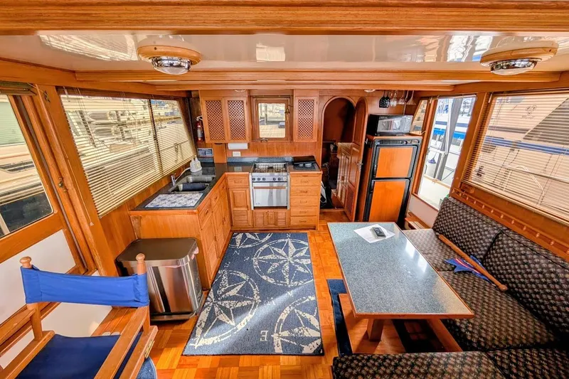 Slide: The Image of Interior of 1987 DeFever Trawler with kitchen, dining area, and nautical decor. - 11