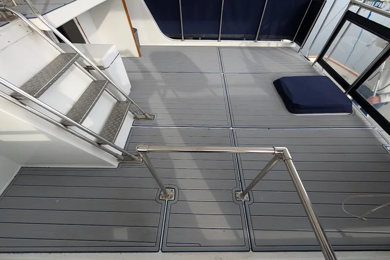 Slide: The Image of 1987 DeFever Trawler deck with metal stairs and cushioned seating area. - 28