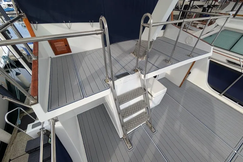 Slide: The Image of 1987 DeFever Trawler deck with metal ladder and railing, featuring gray flooring. - 29