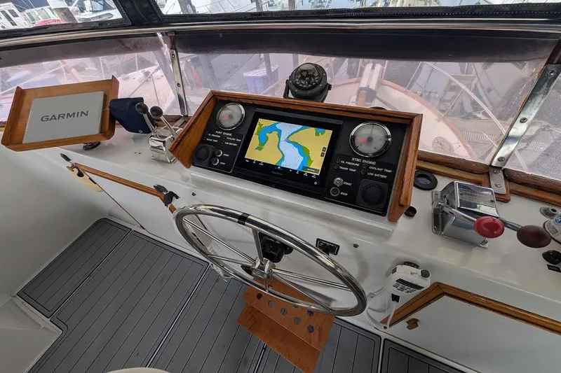 Slide: The Image of 1987 DeFever Trawler helm with Garmin navigation, steering wheel, and control panel. - 33