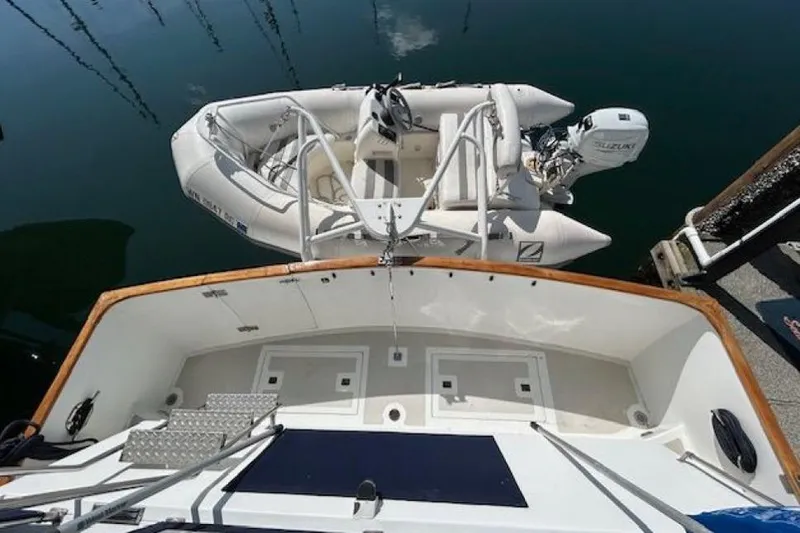 Slide: The Image of 1987 DeFever Trawler with dinghy and Suzuki outboard motor at dock. - 38