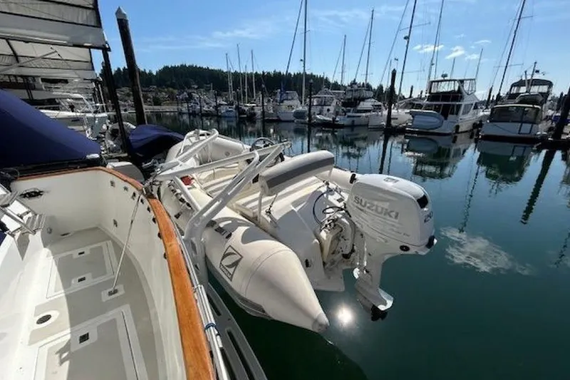 Slide: The Image of 1987 DeFever Trawler with Suzuki outboard motor docked in a marina. - 39