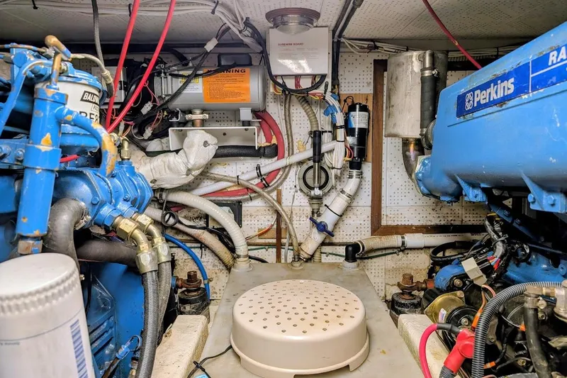 Slide: The Image of Engine room of a 1987 DeFever Trawler with Perkins marine engines and various mechanical components. - 41