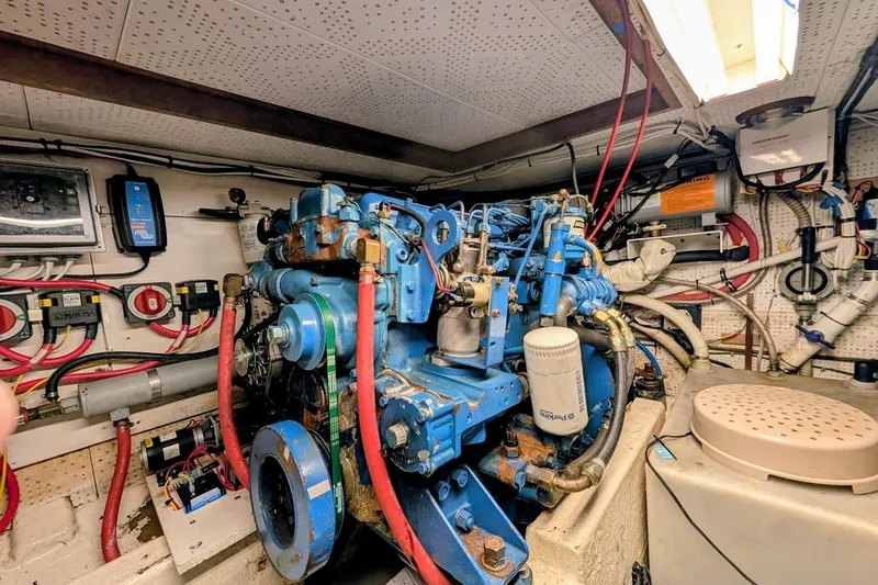 Slide: The Image of Engine room of a 1987 DeFever Trawler with blue machinery and wiring. - 42