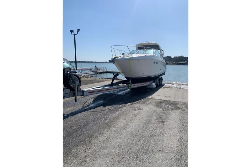 Slide: The Image of 2006 Sea Ray 290 Sundancer boat on trailer by the water. - 4