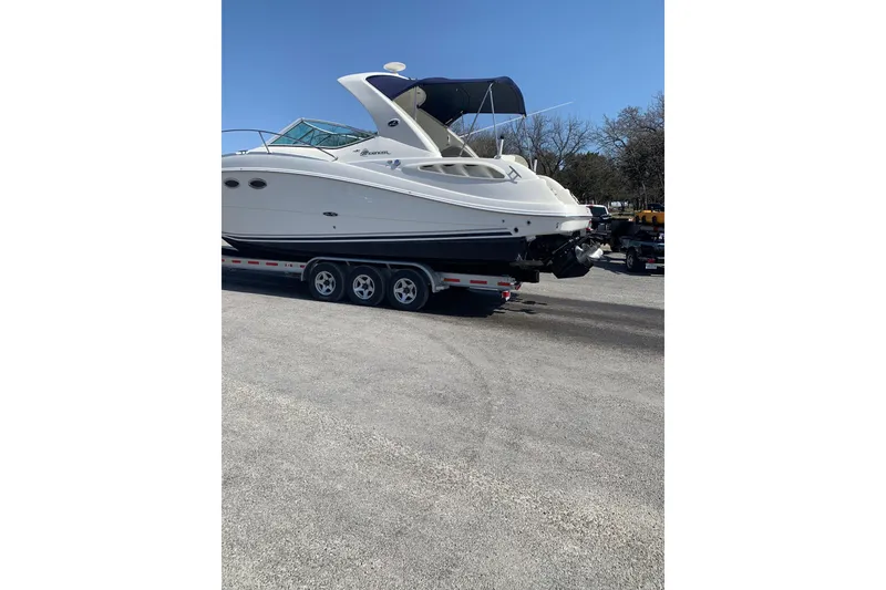 Slide: The Image of 2006 Sea Ray 290 Sundancer boat on trailer under clear blue sky. - 5