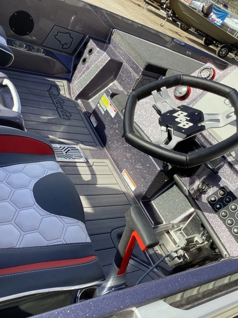 Slide: The Image of 2026 Bass Cat Puma STS with outboard motor and American flag in background. - 12