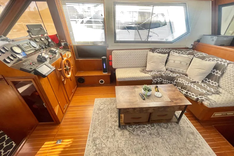 Slide: The Image of 1986 Hi-Star Aft Cabin interior with cozy seating, wooden helm, and nautical decor. - 26