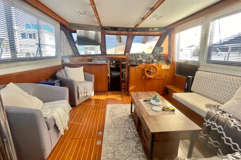 Slide: The Image of 1986 Hi-Star Aft Cabin interior with cozy seating, wooden helm, and nautical decor. - 27