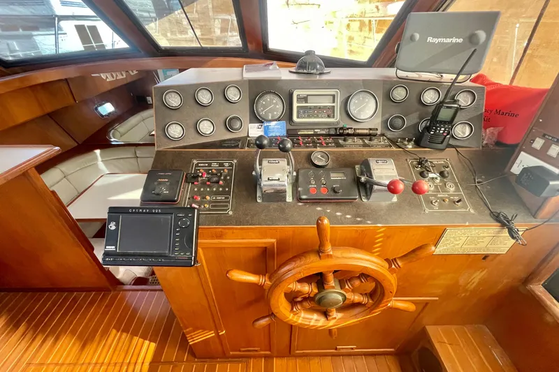 Slide: The Image of 1986 Hi-Star Aft Cabin helm with navigation instruments and wooden steering wheel. - 29