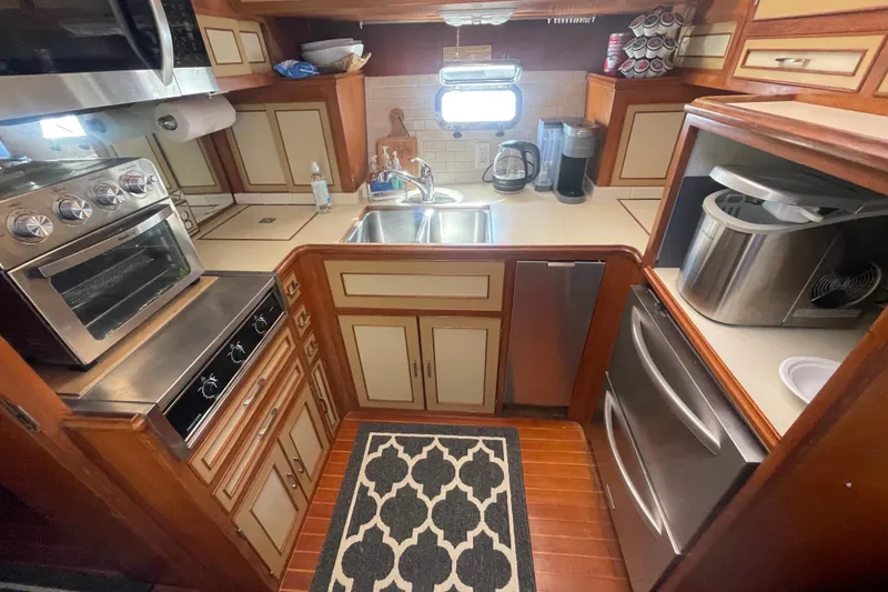 Slide: The Image of 1986 Hi-Star Aft Cabin kitchen with stove, sink, and appliances in compact layout. - 32